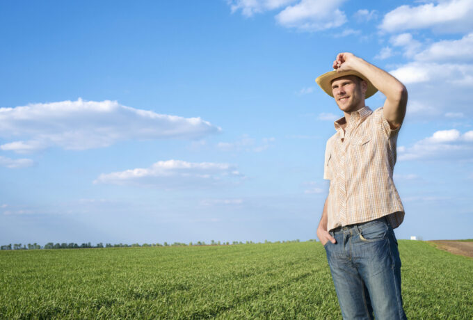 Young farmer in the field observing crops.